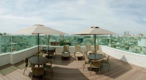 balcón con mesas, sillas y sombrillas en Américas Copacabana Hotel en Río de Janeiro
