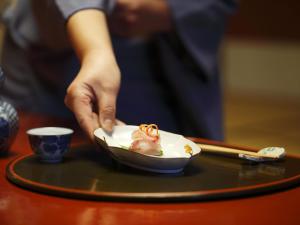 uma pessoa segurando uma tigela de comida em uma mesa em Kinjohro em Kanazawa