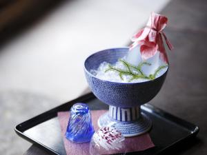 uma tigela azul de comida numa mesa com uma vela em Kinjohro em Kanazawa