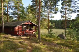 a cabin in the woods with a bench and a table at Hinders Cottages in Nauvo