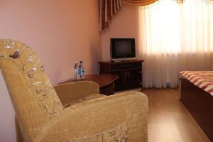 sala de estar con silla y mesa con TV en Passage Hotel en Berehove