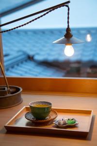 un plato con un tazón en una mesa junto a una ventana en Ryokan Mugen (Adult Only) en Kyoto