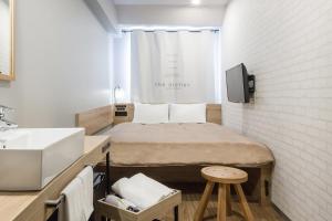 a small room with a bed and a sink at Sakura Terrace The Atelier in Kyoto