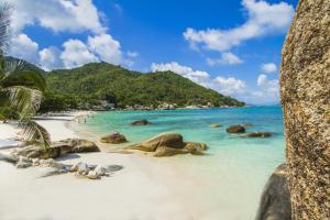 een strand met rotsen en de oceaan met mensen erop bij Crystal Bay Yacht Club Beach Resort in Lamai