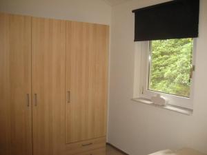 ein Schlafzimmer mit einem Fenster, einer Kommode und einem Fenster in der Unterkunft Recreatiebungalow Lochem in Lochem