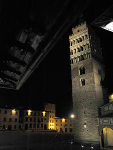 un edificio alto con una torre de reloj por la noche en Appartamento il Battistero en Pistoia