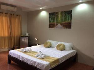 a bedroom with a bed with towels on it at Mañana Hotel in Olongapo