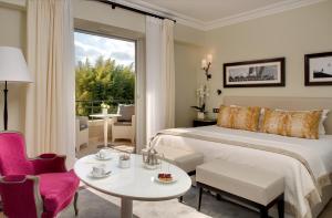 a bedroom with a bed and a table and chairs at Domaine du Mas De Pierre in Saint Paul de Vence