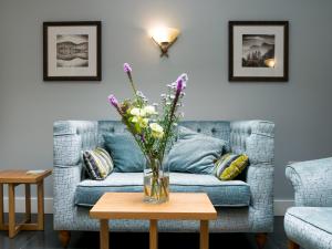 eine Vase mit Blumen auf einem Tisch im Wohnzimmer in der Unterkunft Glaramara Hotel in Borrowdale Valley