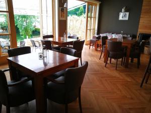 a dining room with wooden tables and chairs at Pensiune Restaurant La Cassa in Vişeu de Sus