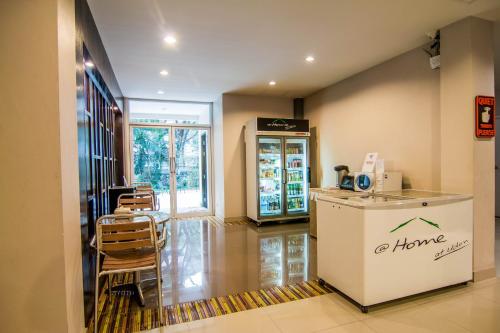 a coffee shop with a counter and chairs in a room at At Home at Udon in Udon Thani