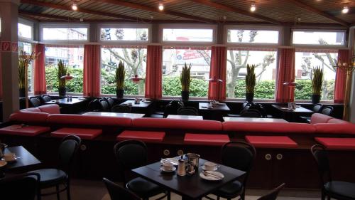 een restaurant met rode banken en tafels bij Hotel Böll Essen in Essen