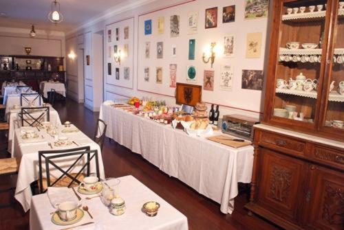 une salle avec deux tables avec des nappes blanches dans l'établissement Posada Real Casa de Tepa, à Astorga