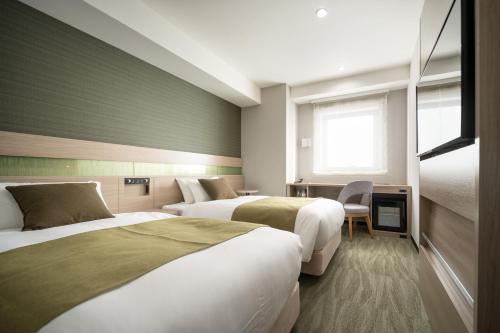 Tempat tidur dalam kamar di Nest Hotel Hakata Station