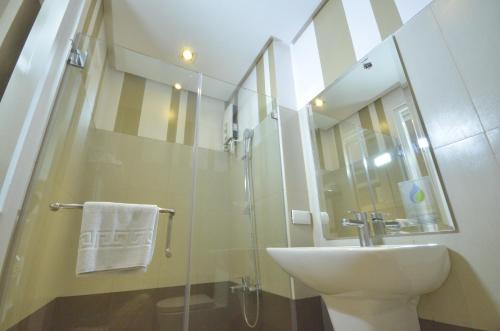 Injap Tower Hotel في إيلويلو سيتي: حمام مع حوض ودش زجاجي