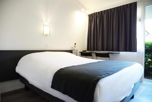 Una cama o camas en una habitación de Aerel Hotel Aéroport Blagnac