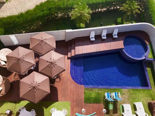 an overhead view of a swimming pool with umbrellas and chairs at Nord Easy Camboinha in Cabedelo