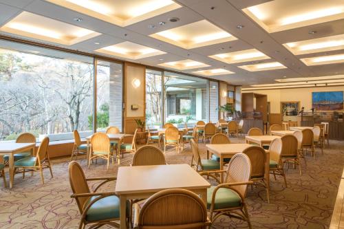 una sala da pranzo con tavoli, sedie e finestre di Fuji View Hotel a Fujikawaguchiko