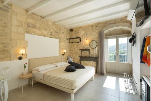 a bedroom with a bed and a stone wall at Evoca in Ragusa