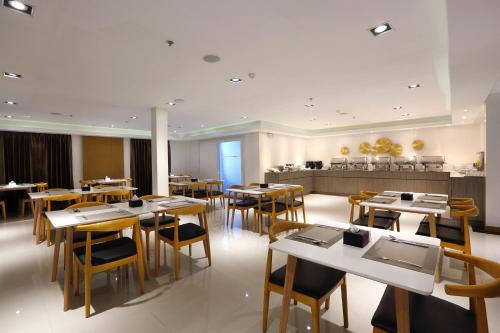 a restaurant with tables and chairs and a cafeteria at K.C Hotel in Yangon