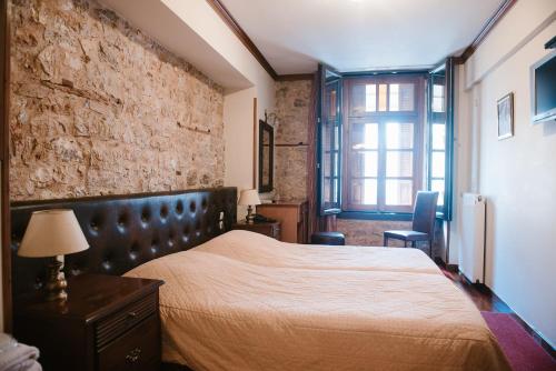 a bedroom with a bed and a brick wall at Kentrikon in Ioannina