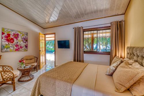 a bedroom with a bed and a chair and a window at Yucca Beachfront Hotel in Puerto Viejo