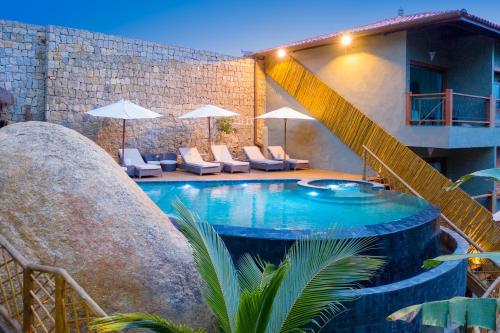 a swimming pool with a staircase next to a building at Hotel Vila Kebaya in Ilhabela