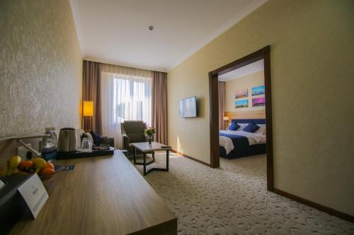 a hotel room with a bed and a large mirror at Rayan Hotel in Osh