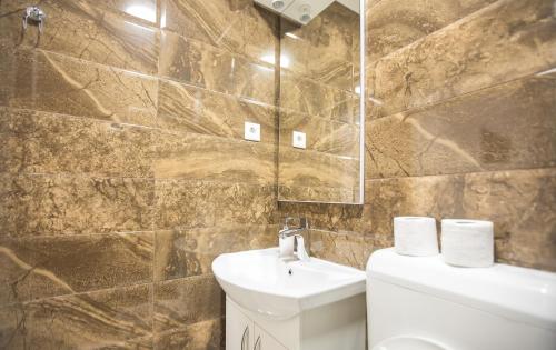 a bathroom with a sink and a toilet and a mirror at Pansion Kipovi in Tuzla