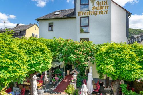 un edificio con árboles y sombrillas delante de él en Goldener Pfropfenzieher, en Oberwesel