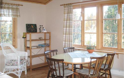 una sala da pranzo con tavolo, sedie e finestre di Gorgeous Home In Silverdalen With Kitchen a Silverdalen