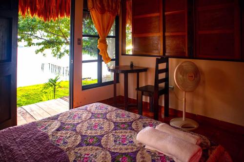 a bedroom with a bed and a window and a fan at Mayan Spirit in Flores