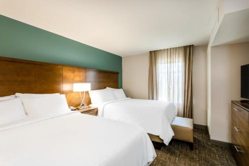 سرير أو أسرّة في غرفة في Staybridge Suites - Fort Lauderdale Airport - West, an IHG Hotel