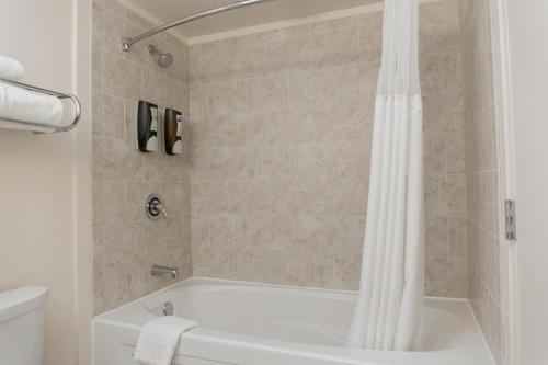 La salle de bains est pourvue d'une baignoire blanche et d'une douche. dans l'établissement Chicago South Loop Hotel, à Chicago