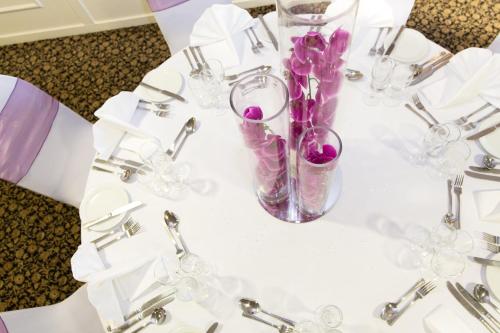 un tavolo bianco con fiori viola in un vaso di Seacote Hotel a St Bees