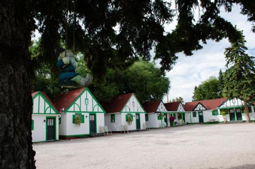 eine Reihe von weißen und grünen Häusern mit einem Baum in der Unterkunft Chalet Motel in Custer