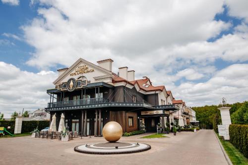 un gran edificio con una gran bola dorada delante de él en Hotel Luxor en Lublin