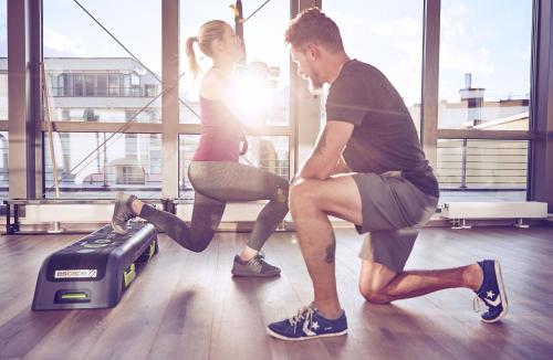 un homme et une femme qui courent dans une salle de sport dans l'établissement Hotel Josef, à Prague