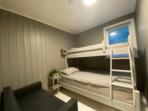 a small room with a bunk bed and a chair at Askevika in Vikum