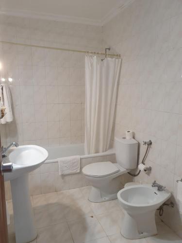 La salle de bains blanche est pourvue de toilettes et d'un lavabo. dans l'établissement Hotel Novo Dia, à Mêda