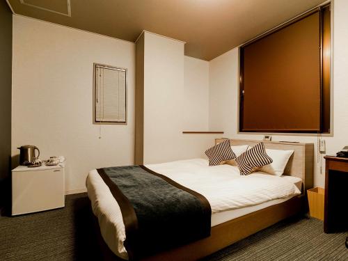 A bed or beds in a room at Hotel AreaOne Nobeoka