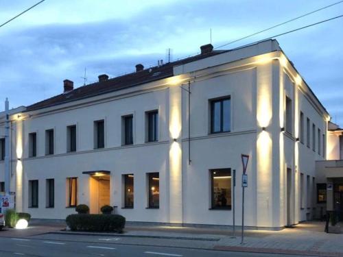 un edificio blanco con luces en el costado en Hotel KOZÁK, en Brno