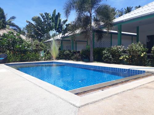 a swimming pool in front of a house at Sunya Cottage in Lamai