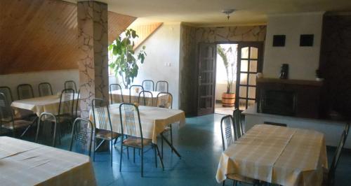 a dining room with tables and chairs in a building at Dudás panzió in Bükkszentkereszt