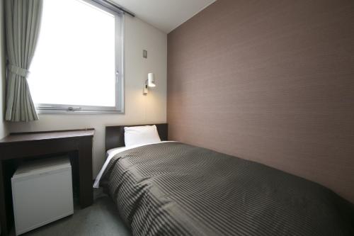 a small bedroom with a bed and a window at Okadaya Bayside - Vacation STAY 00055v in Toyohashi