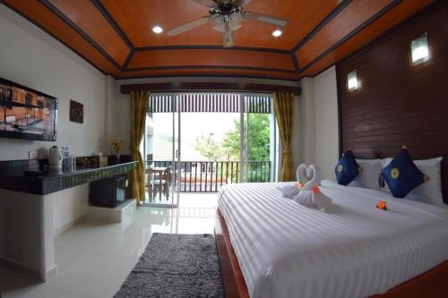 - une chambre avec un grand lit et une grande fenêtre dans l'établissement Vivi Boutique Room Hotel SHA Plus, à Rawai Beach