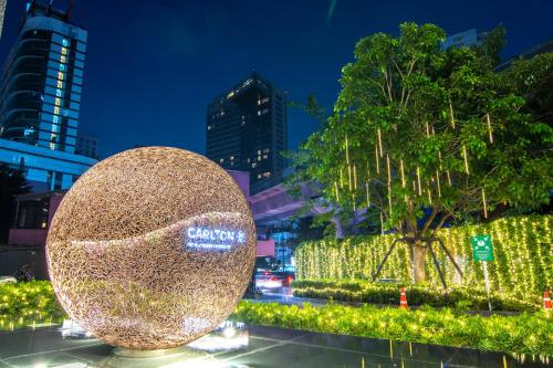 ein großer Goldball vor einem Baum mit Lichtern in der Unterkunft Carlton Hotel Bangkok Sukhumvit in Bangkok