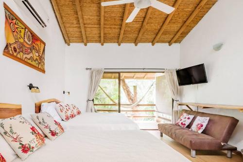 um quarto com 2 camas e uma televisão de ecrã plano em Dreamcatcher Hotel - Atrapasueños em Santa Teresa