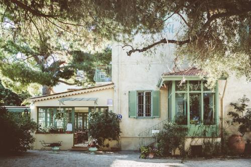 a house with green shutters and a window at Hotel Le Ponteil in Antibes