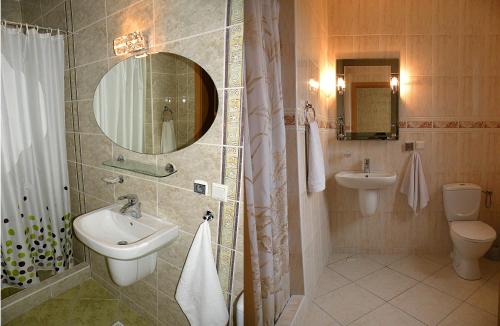 uma casa de banho com um lavatório, um WC e um espelho. em Hotel Hawana em Bydgoszcz